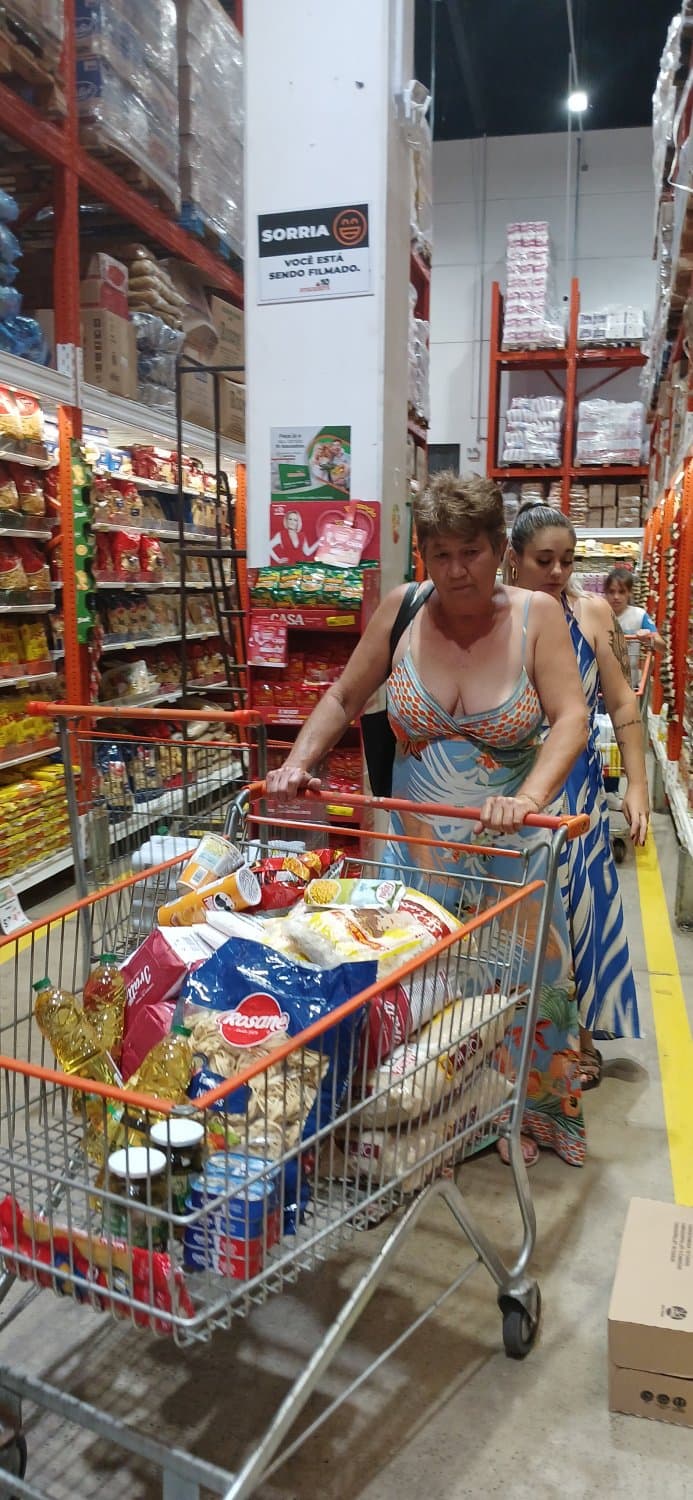 Old woman wearing a dress without a bra and with a very low neckline.