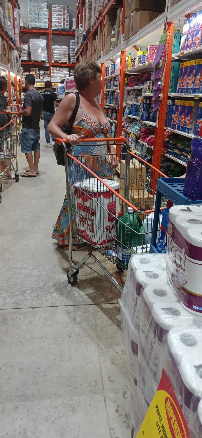 Old woman wearing a dress without a bra and with a very low neckline.