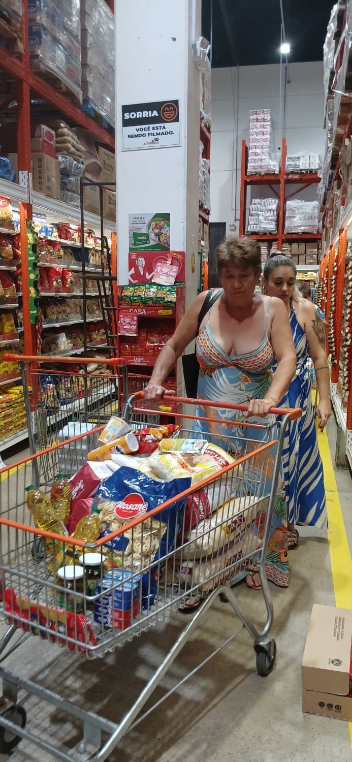 Old woman wearing a dress without a bra and with a very low neckline.