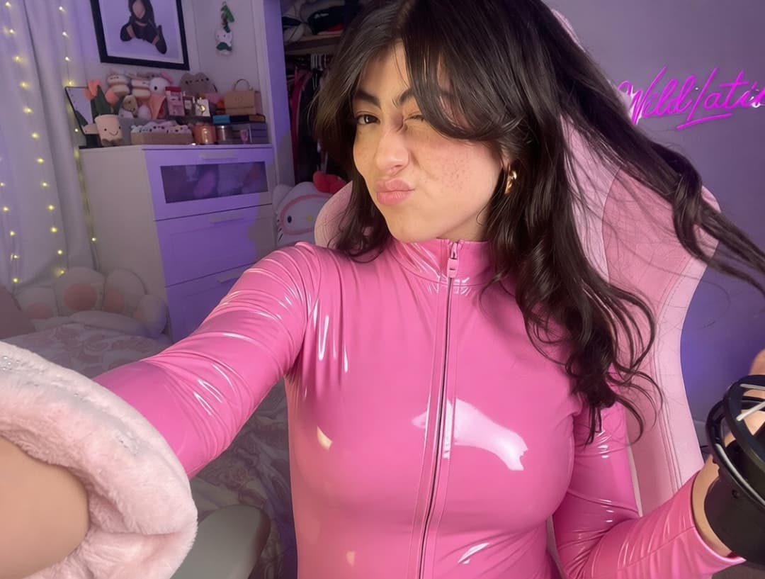 Twitch streamer thewildlatina in a pink vinyl catsuit