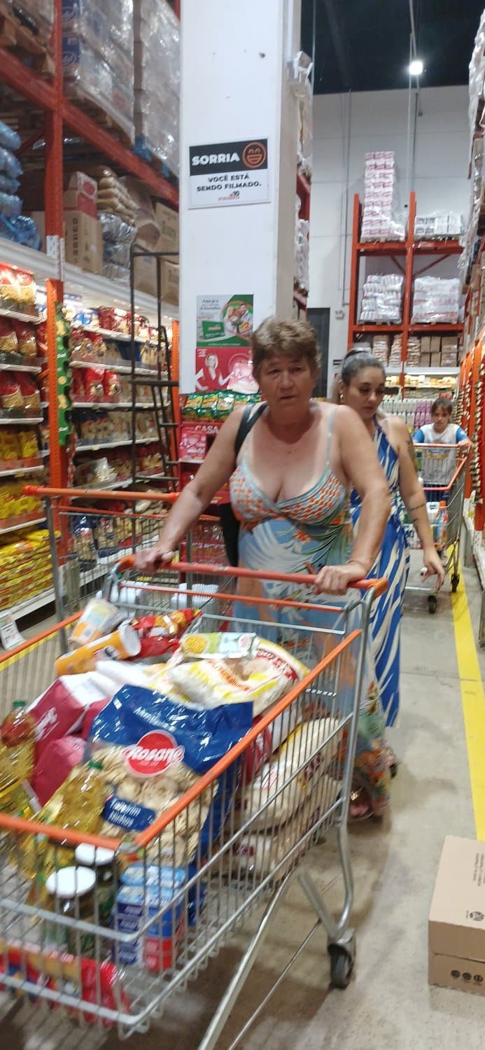 Old woman wearing a dress without a bra and with a very low neckline.