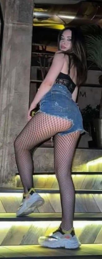 Sexy brunette with sexy legs in fishnets booty shorts showing of her ass