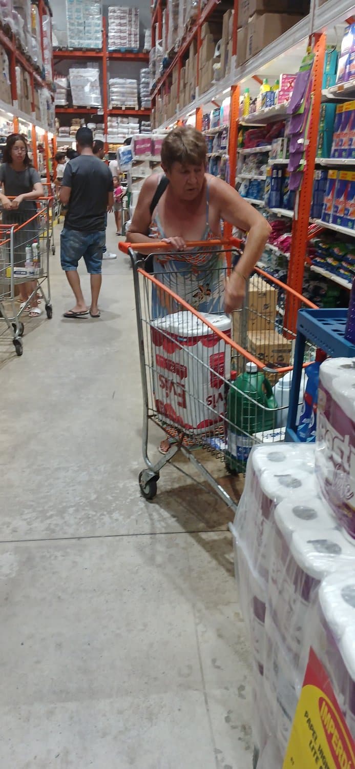 Old woman wearing a dress without a bra and with a very low neckline.