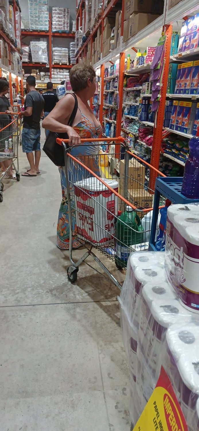 Old woman wearing a dress without a bra and with a very low neckline.