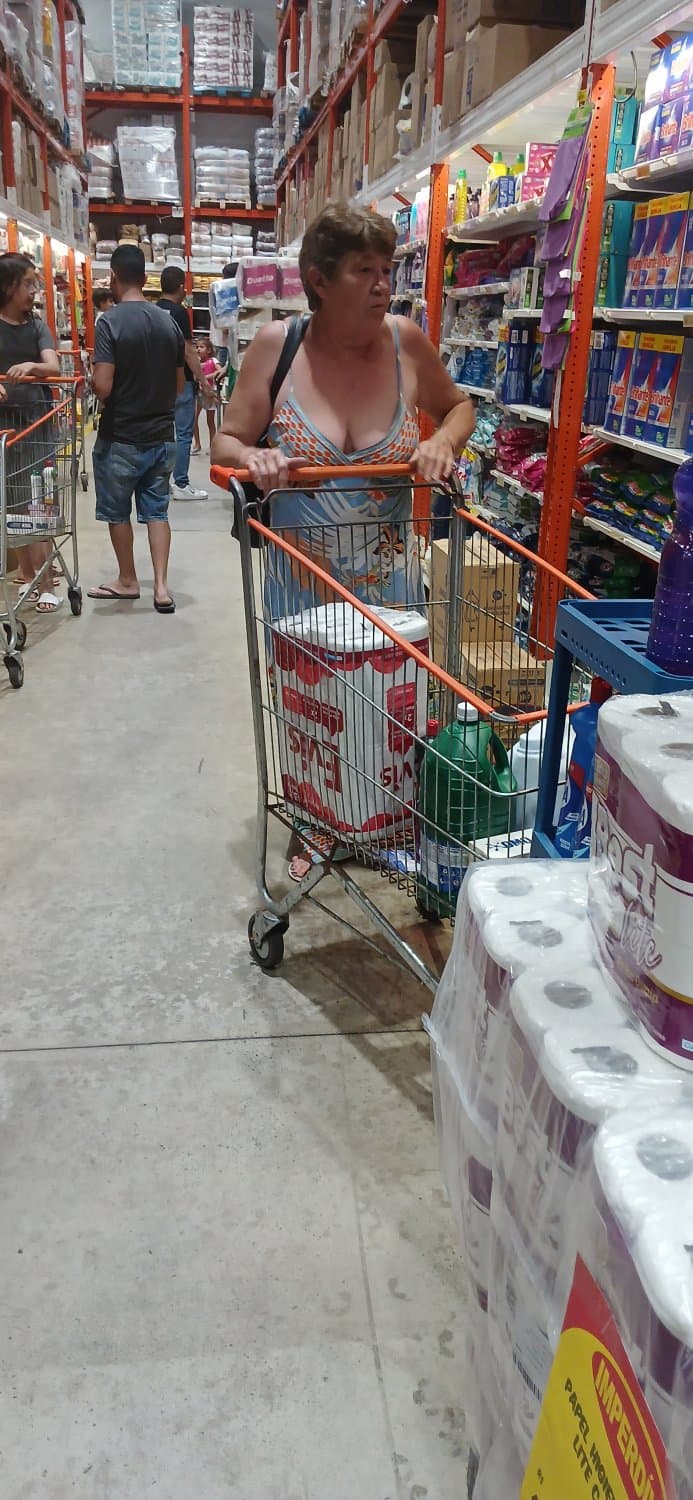 Old woman wearing a dress without a bra and with a very low neckline.