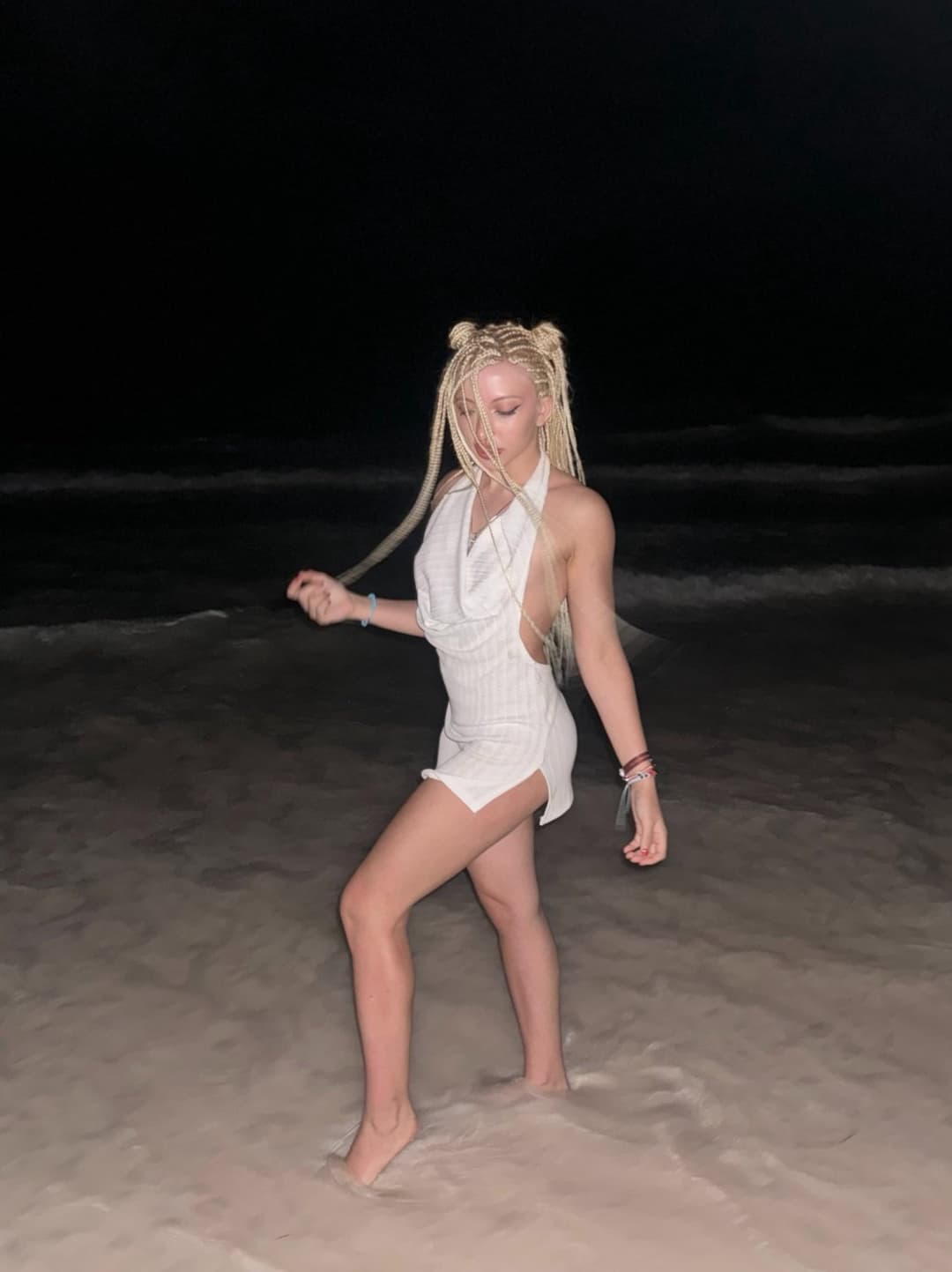 Soft waves,  dark skies, she glows in the dark