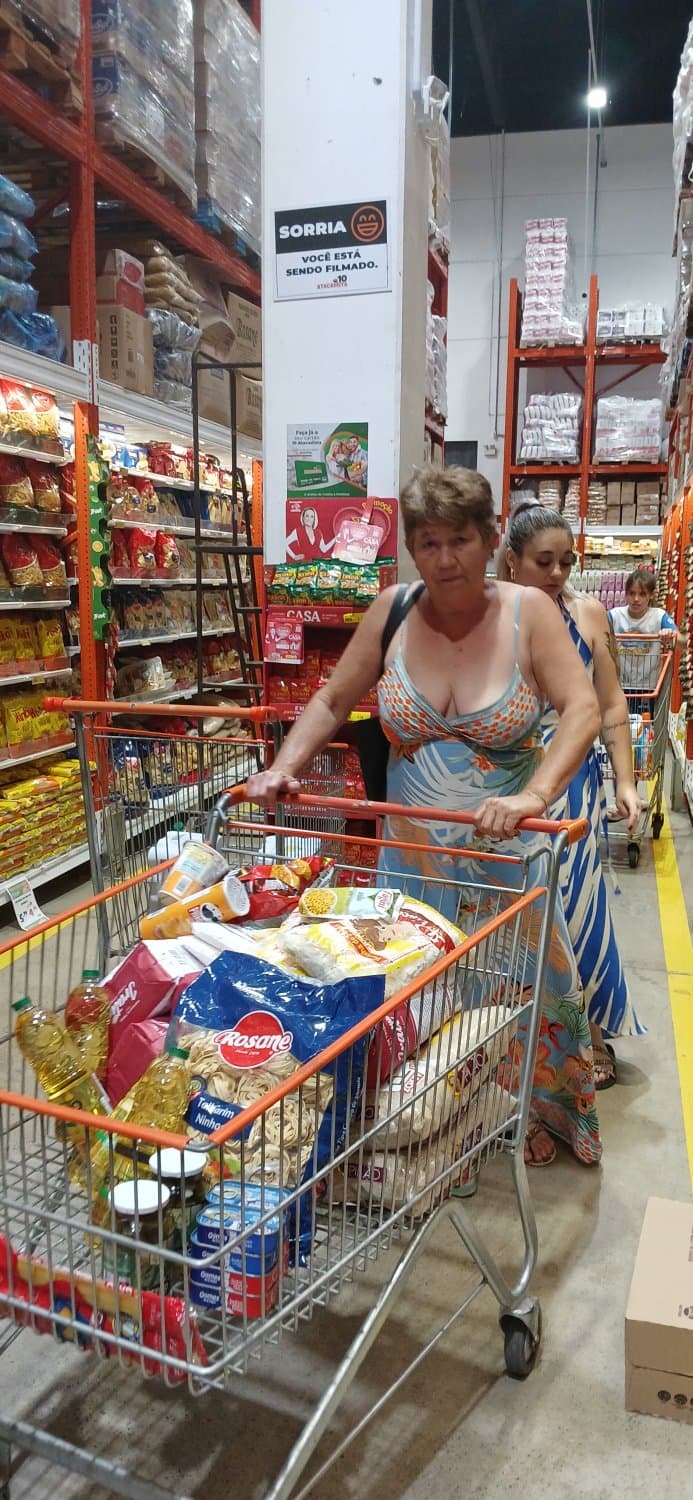 Old woman wearing a dress without a bra and with a very low neckline.