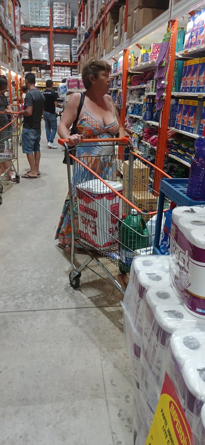 Old woman wearing a dress without a bra and with a very low neckline.