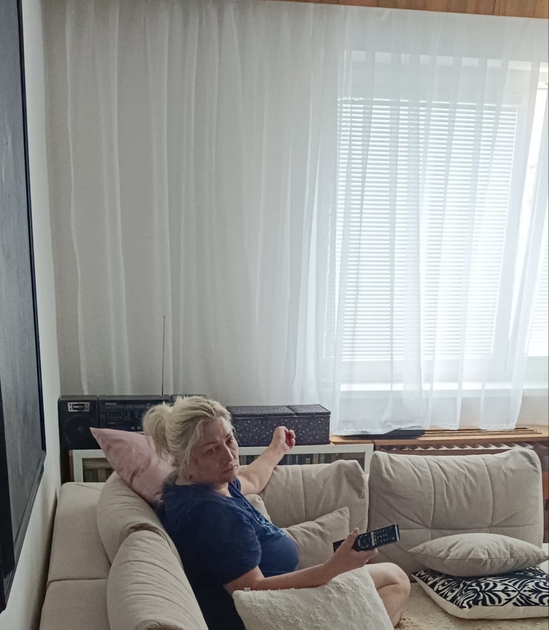 My aunt chillin,watching tv.