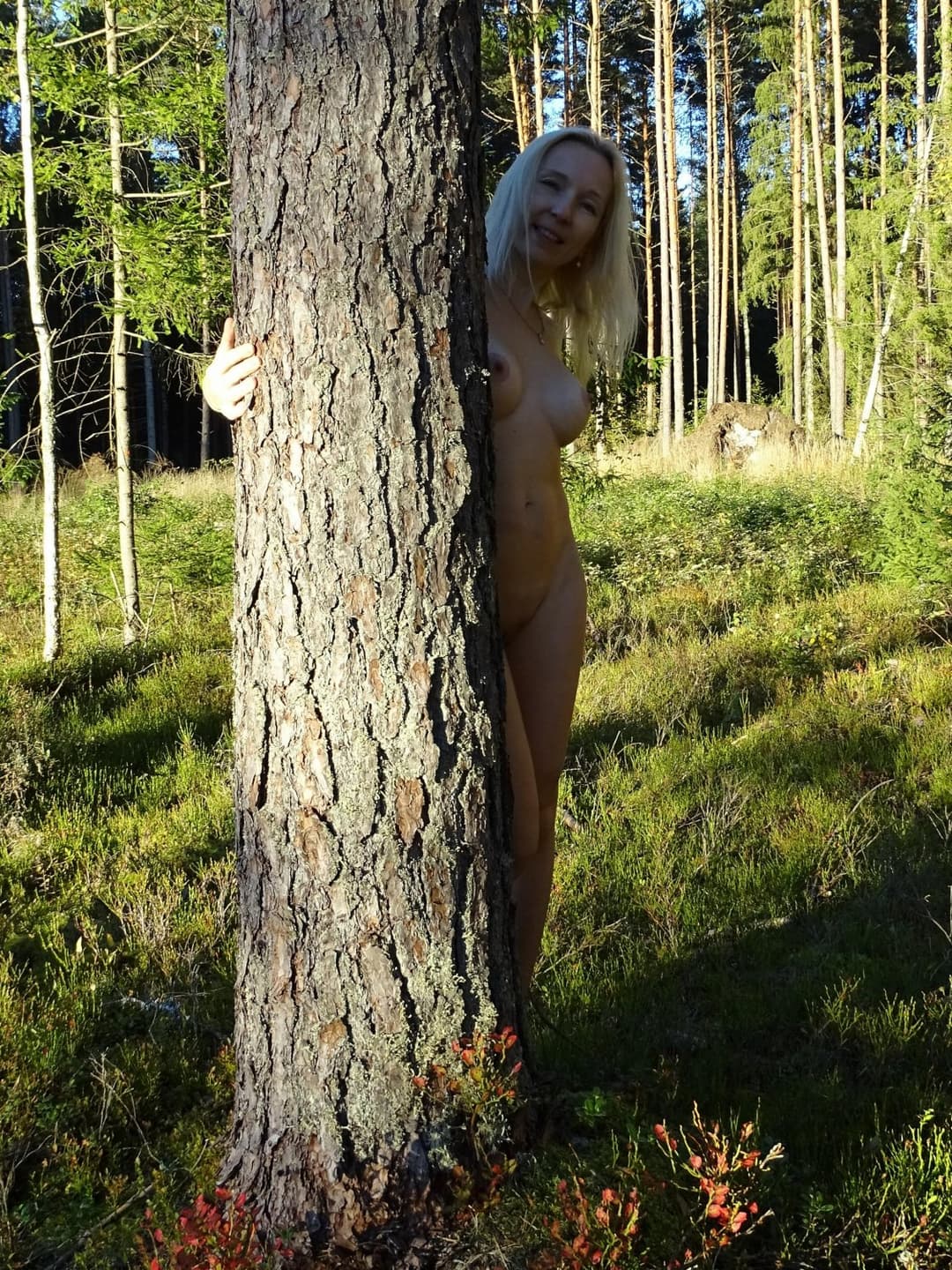 Amateur Skinny Blonde milf with fake tits shows herself in sunny forest outdoors. Buttplug in ass.